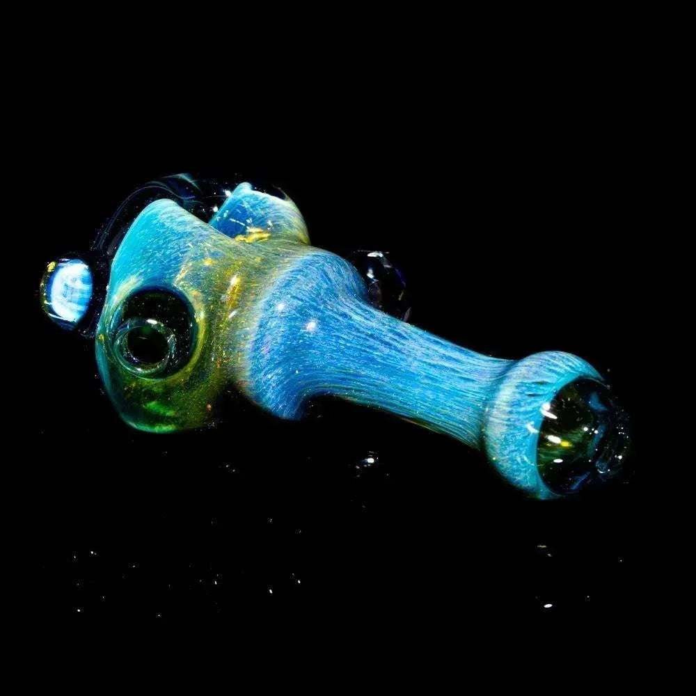 Colorful faceted glass hand pipe with honeycomb pattern on a black background.