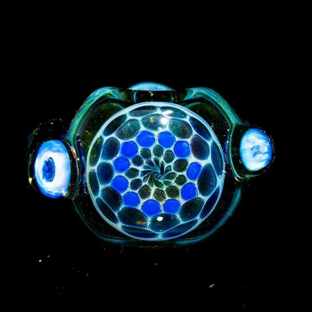 Close-up of a honeycomb faceted glass spoon pipe with blue and clear geometric design
