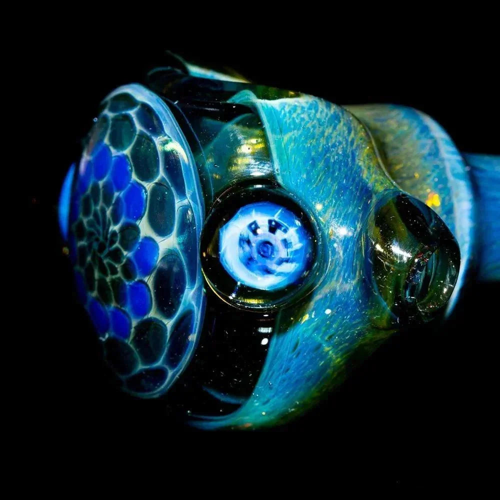 Blue and gold honeycomb faceted glass spoon pipe with intricate patterns, close-up view.