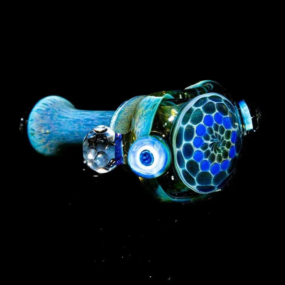 Blue honeycomb faceted glass spoon pipe with intricate patterns on a black background.