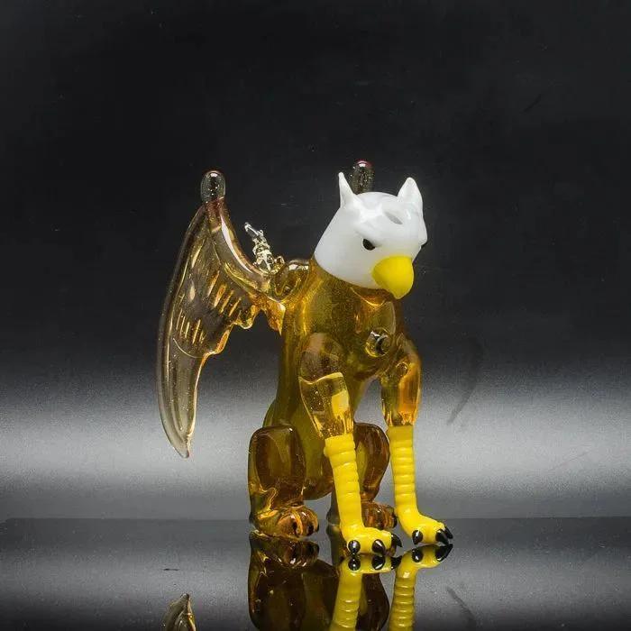 Hand-blown glass eagle pipe with amber body, white head, yellow beak, and detailed wings for smoking accessories.