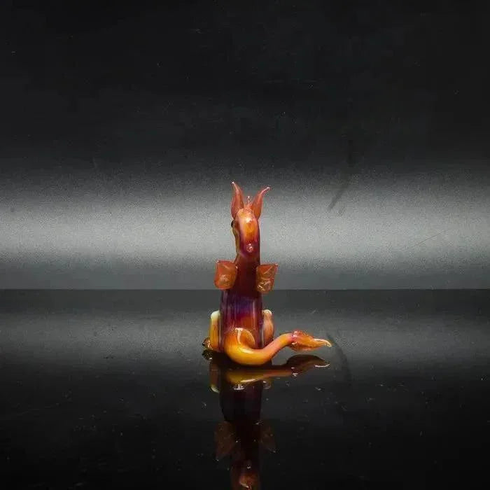 Hand-blown glass dragon sculpture with vibrant orange and purple hues, perfect for heady glass collectors.