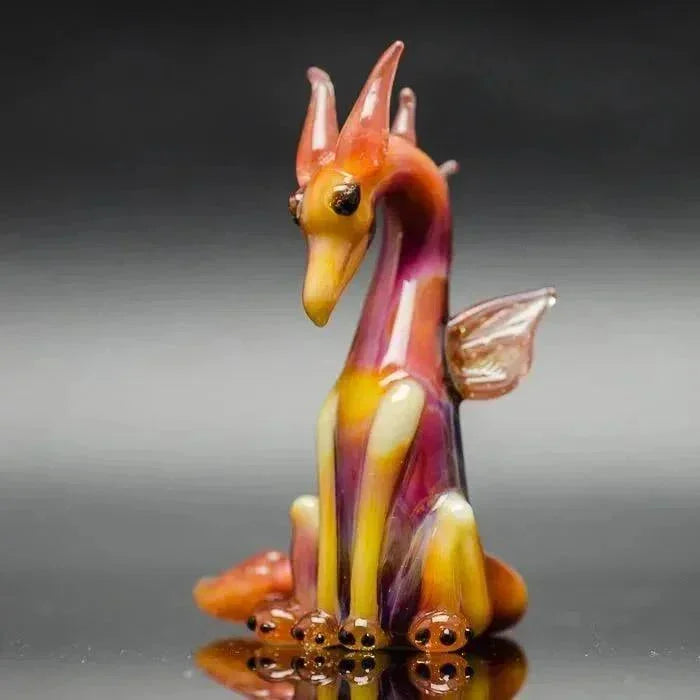 Colorful glass dragon figurine with vibrant orange, purple, and yellow hues, detailed wings and horns