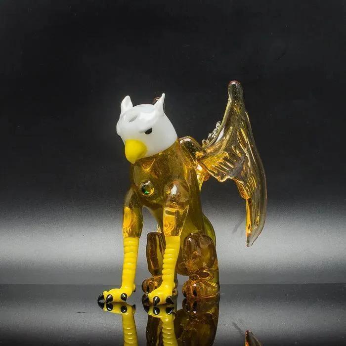 Amber glass eagle figurine with white head and yellow beak, showcasing intricate wings and claws