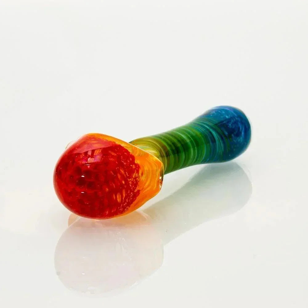 Rainbow frit honeycomb glass spoon pipe with vibrant colors on white background