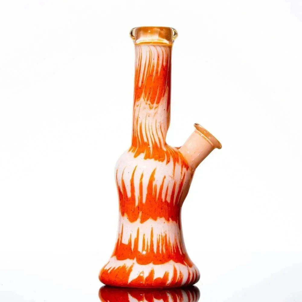 Orange and white frit glass water pipe with unique swirled pattern on white background