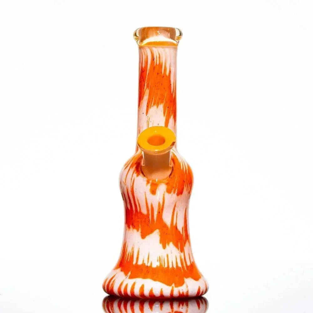 Orange and white glass water pipe with fritted swirl design on a white background