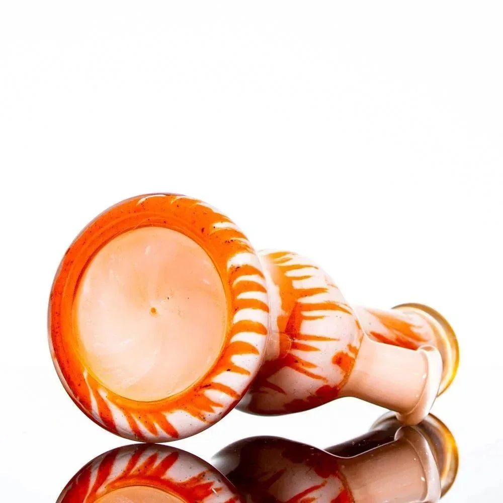 Orange and white glass water pipe with frit pattern, displayed on reflective surface