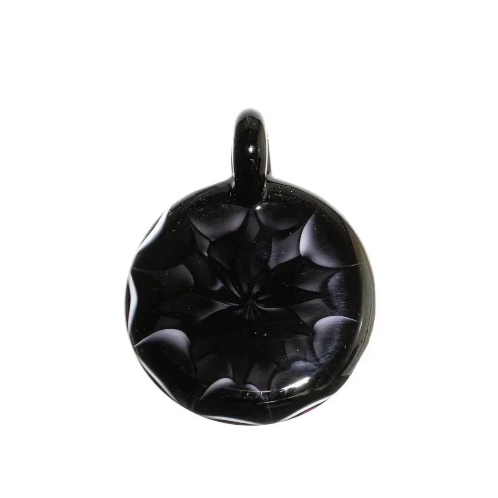Hand-blown black glass pendant with geometric starburst design, photographed on white background.