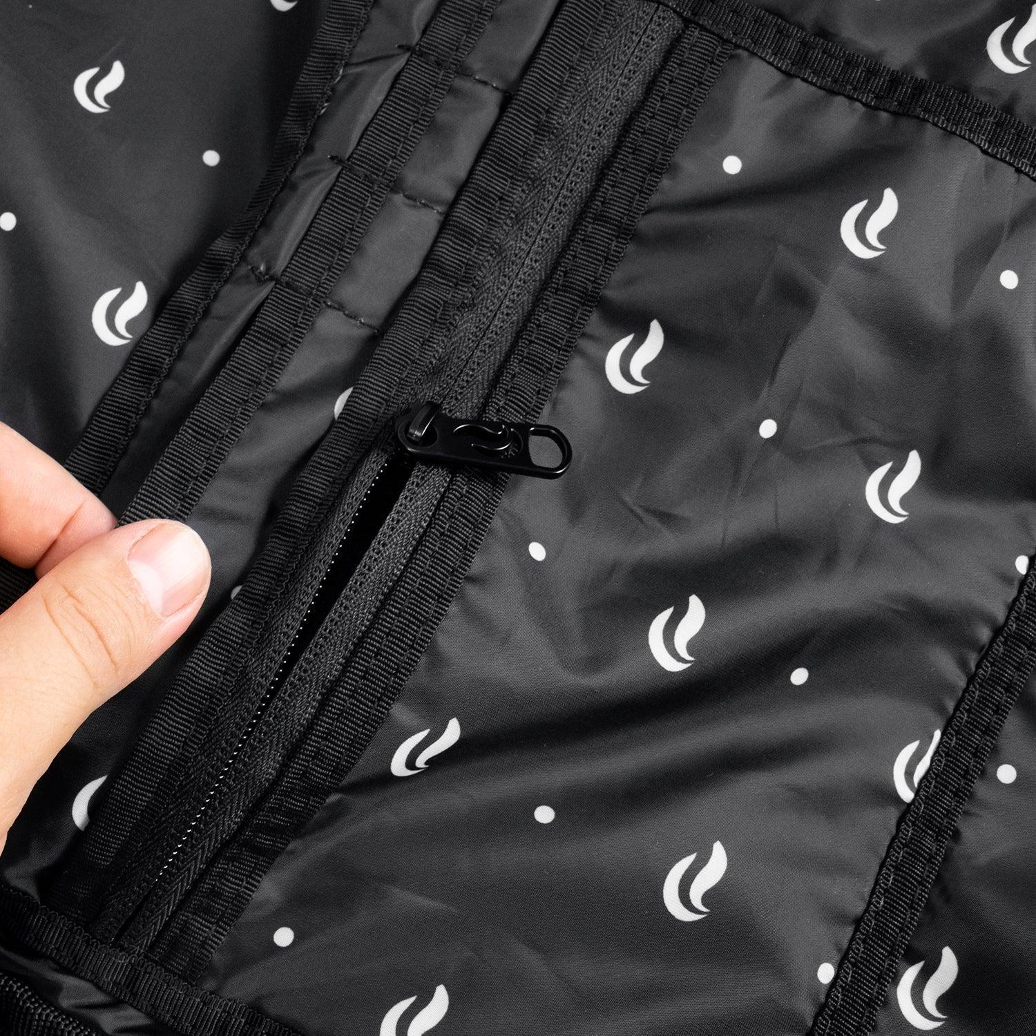 Black jacket interior pocket with zipper and white flame pattern, close-up view