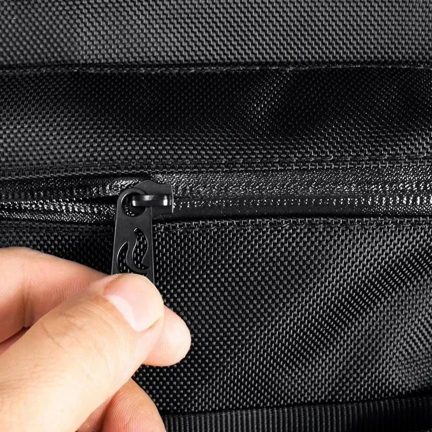 Hand holding black zipper on textured smell-proof bag pocket