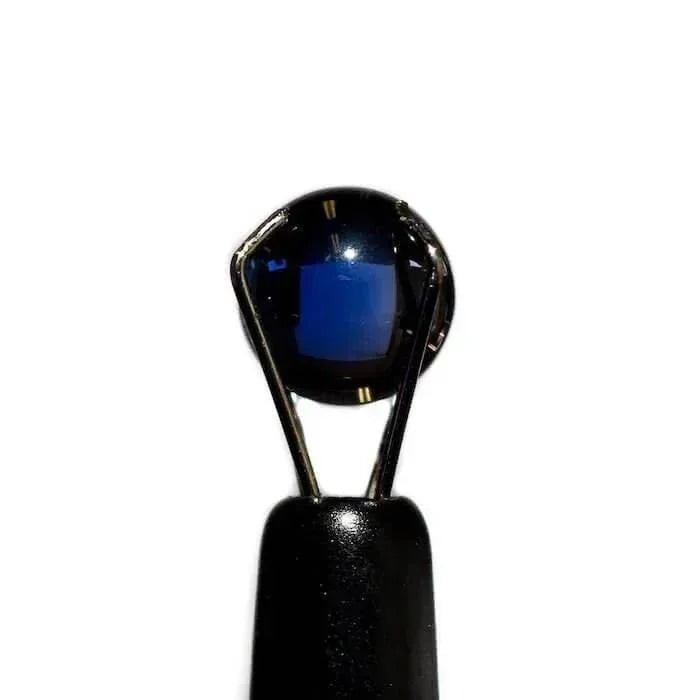6mm round blue sapphire terp pearl held by tweezers on white background