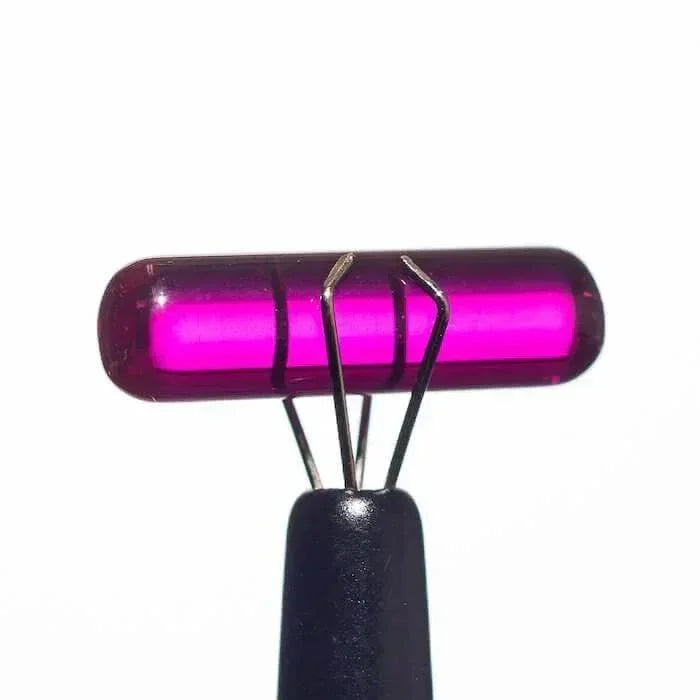 Vibrant pink glass carb cap with metal prongs, ideal for dab rigs and vaporizers