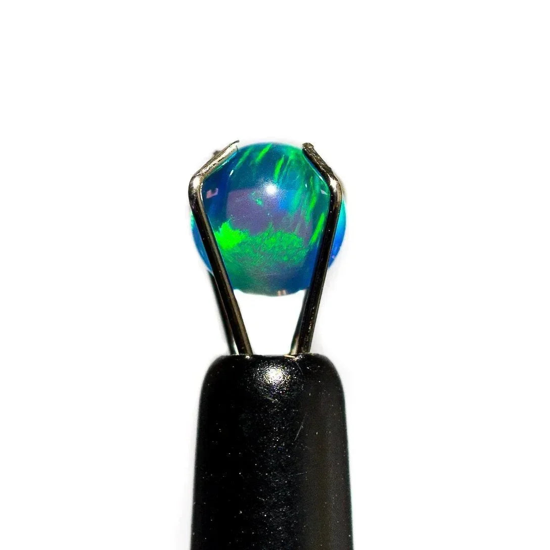 5mm blue opal glass dab pearl held by metal tweezers on white background