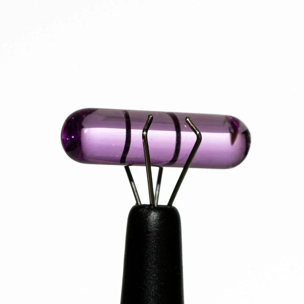 Purple glass pillar carb cap with black stripes for dab rigs, isolated on white background