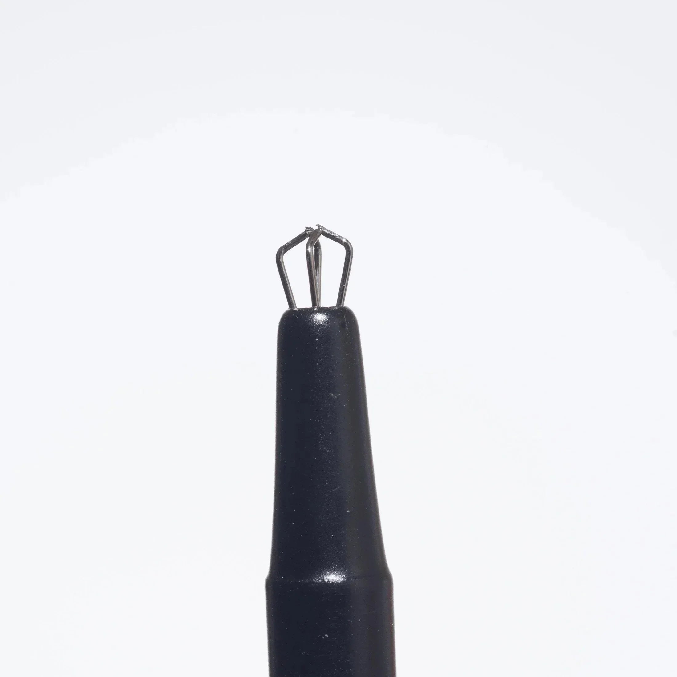 Black dab tool with claw grabber tip for handling glass pearls, isolated on white background