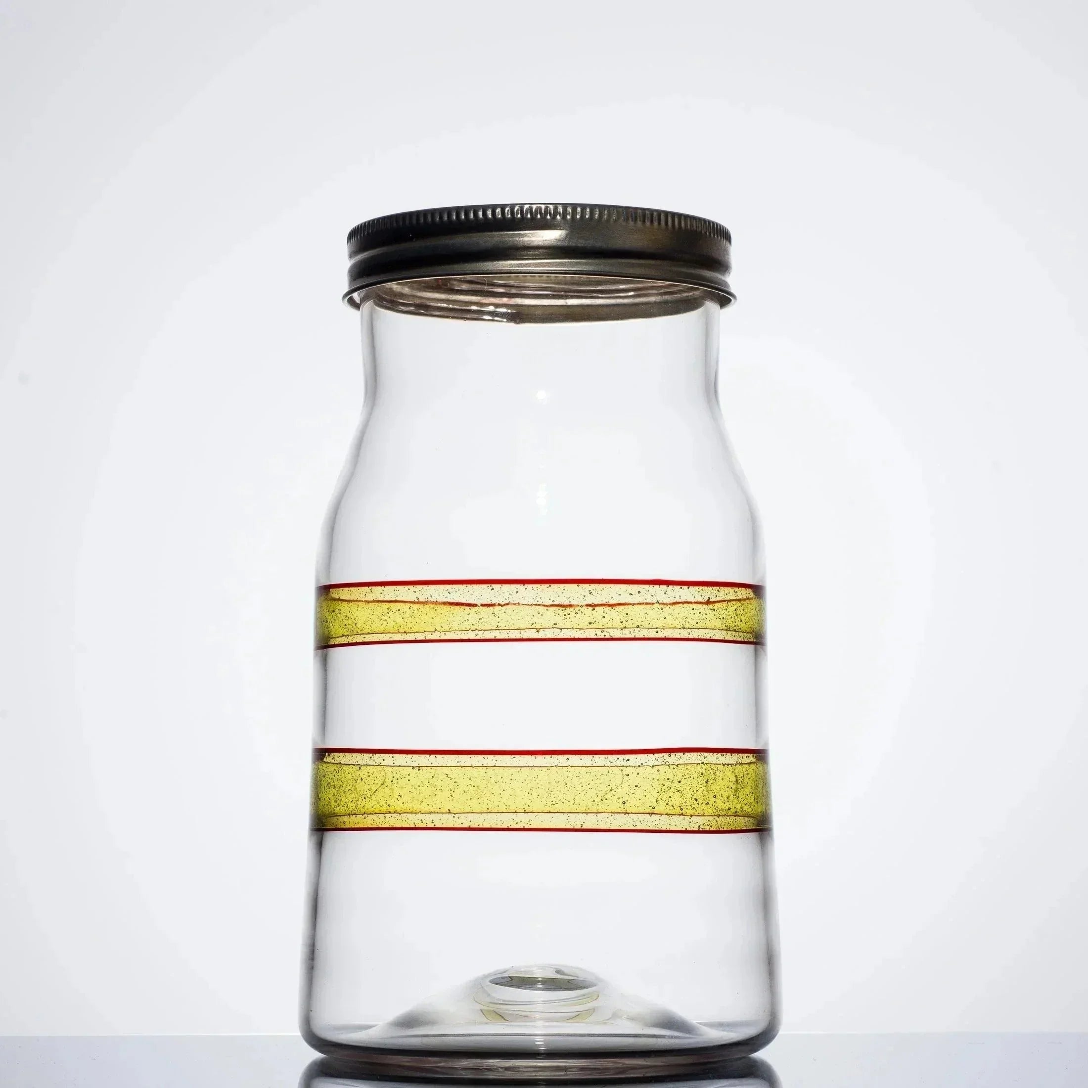 Clear glass jar with yellow and red stripes, metal lid, minimalist design