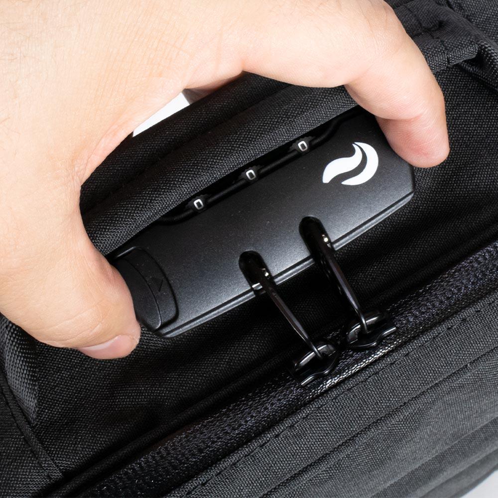 Hand holding a black bag with a zipper and built-in combination lock