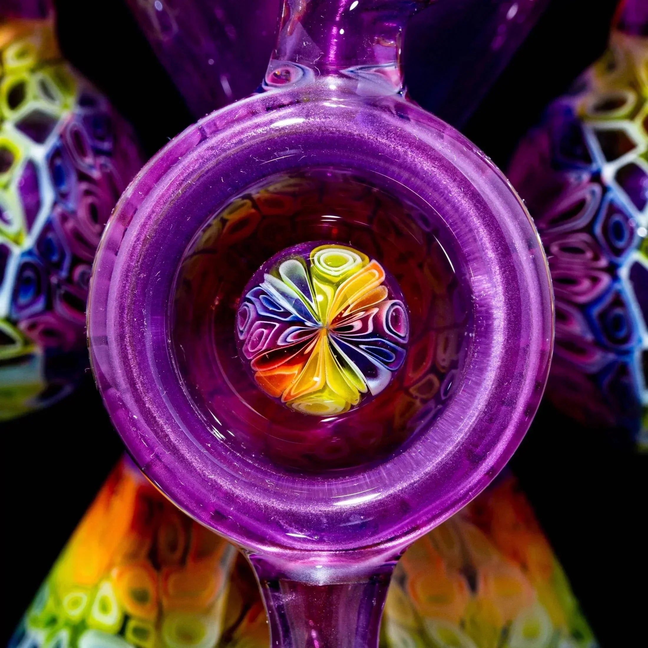 Close-up of a colorful heady glass pipe with intricate rainbow patterns and purple details.