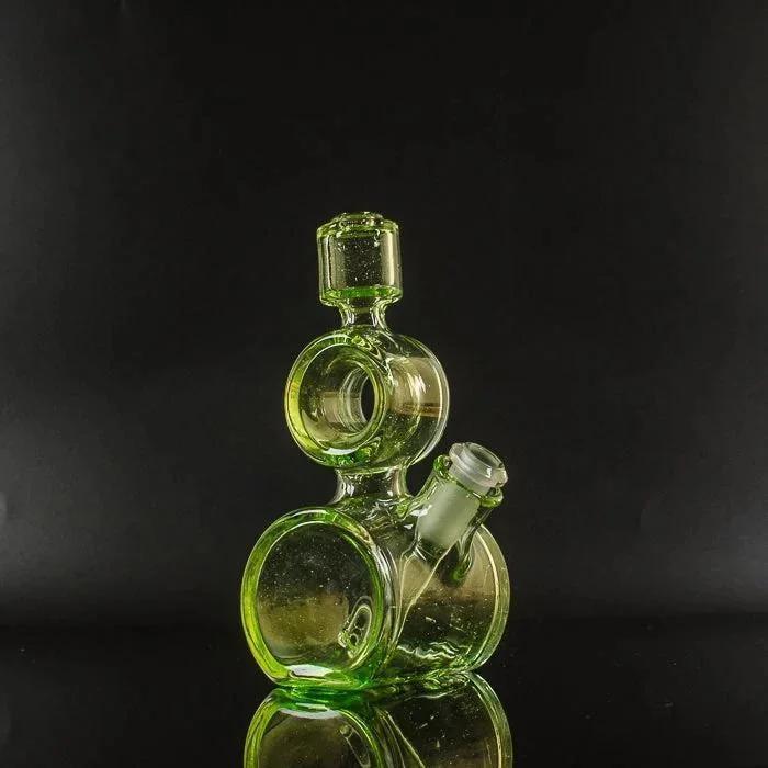 Vibrant green heady glass bubbler with stacked chambers and angled mouthpiece, showcased against black background