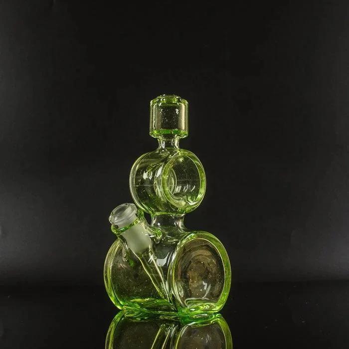 Vibrant green heady glass bong with stacked bubble chambers and clear stem, studio-lit against black background
