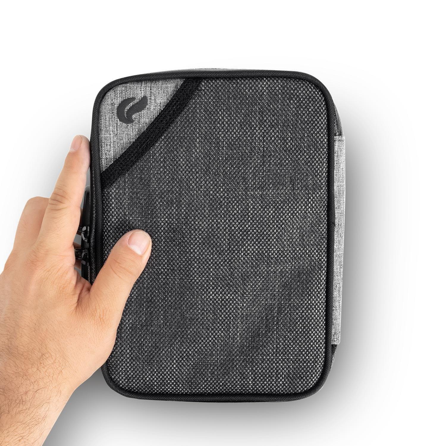 Hand holding a compact gray smell proof storage case with zipper and textured fabric