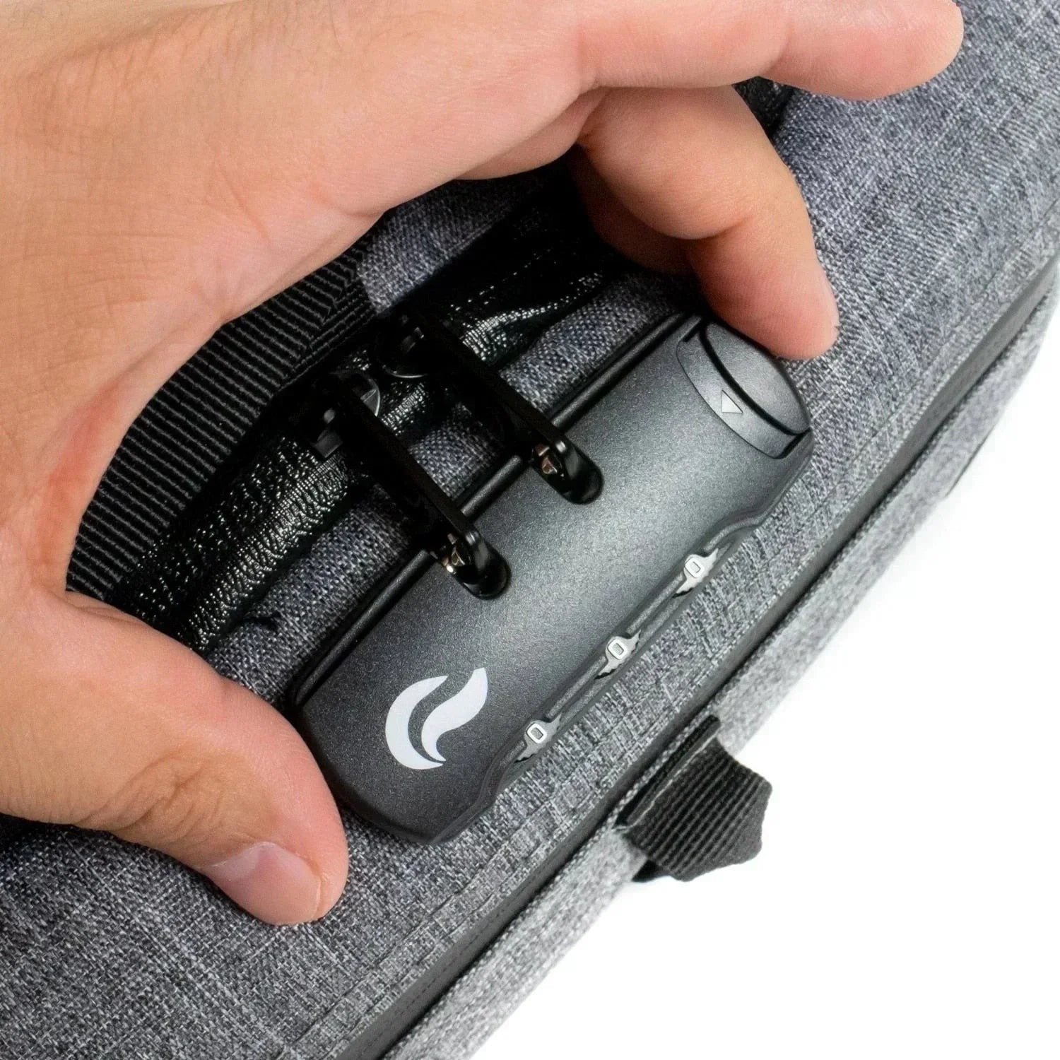 Close-up of hand setting combination lock on gray duffle bag with textured fabric