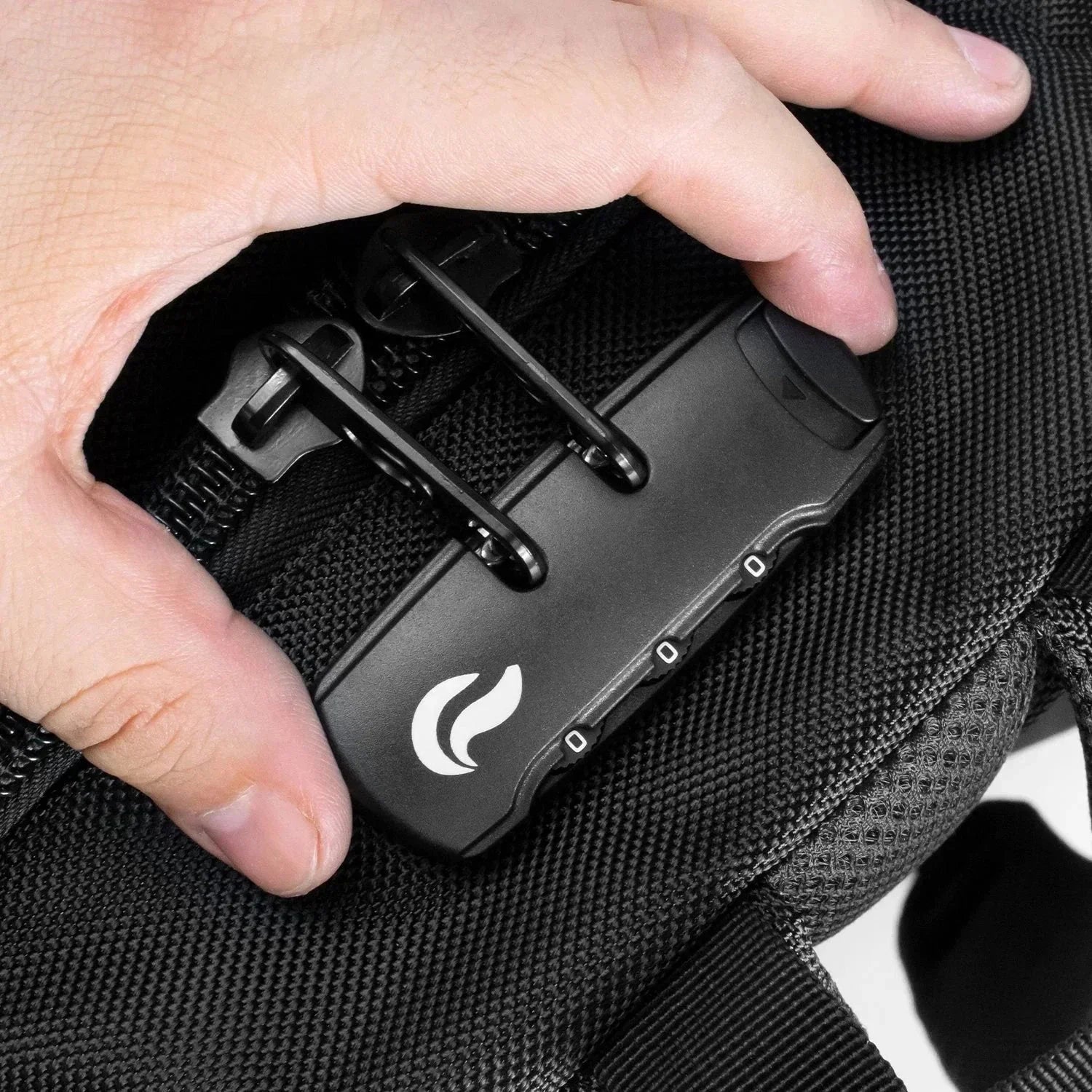 Close-up of a black combination lock securing zippers on a textured black backpack.