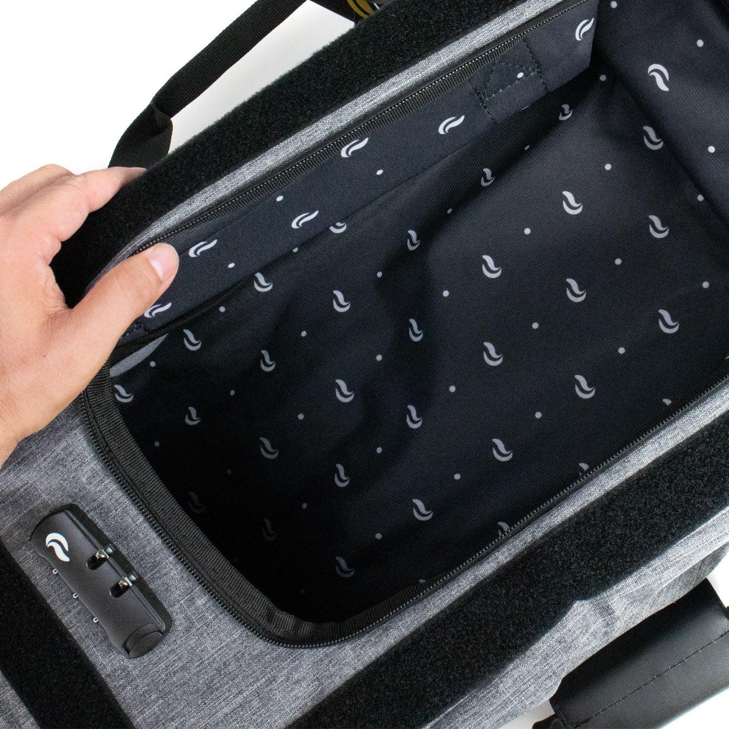 Open gray duffle bag with patterned black interior and built-in combination lock