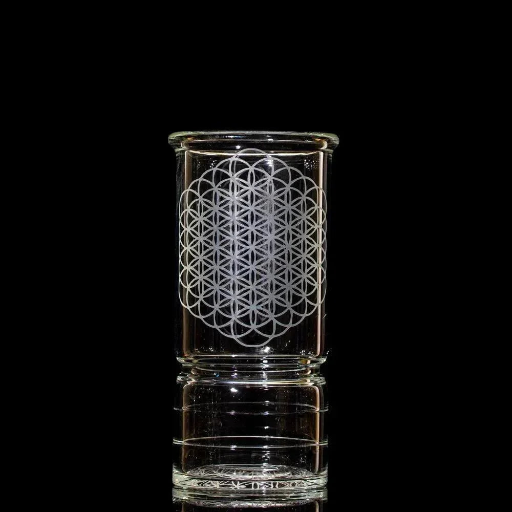 Clear tall glass cup with geometric etched pattern on black background