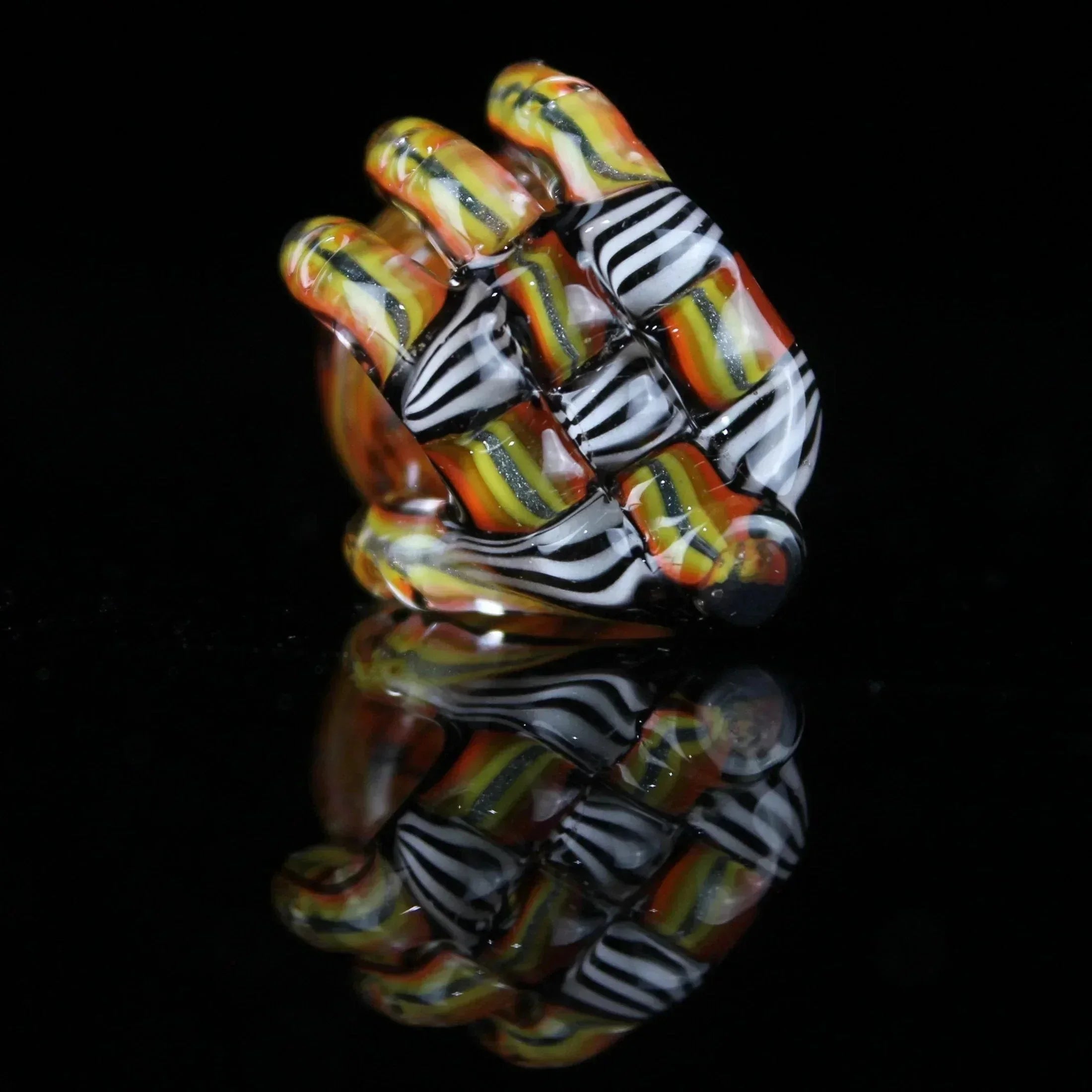Colorful glass smoking accessory with orange, yellow, and black striped woven design