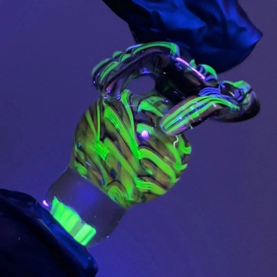 UV reactive glass banger accessory with neon green and black swirl pattern under blacklight