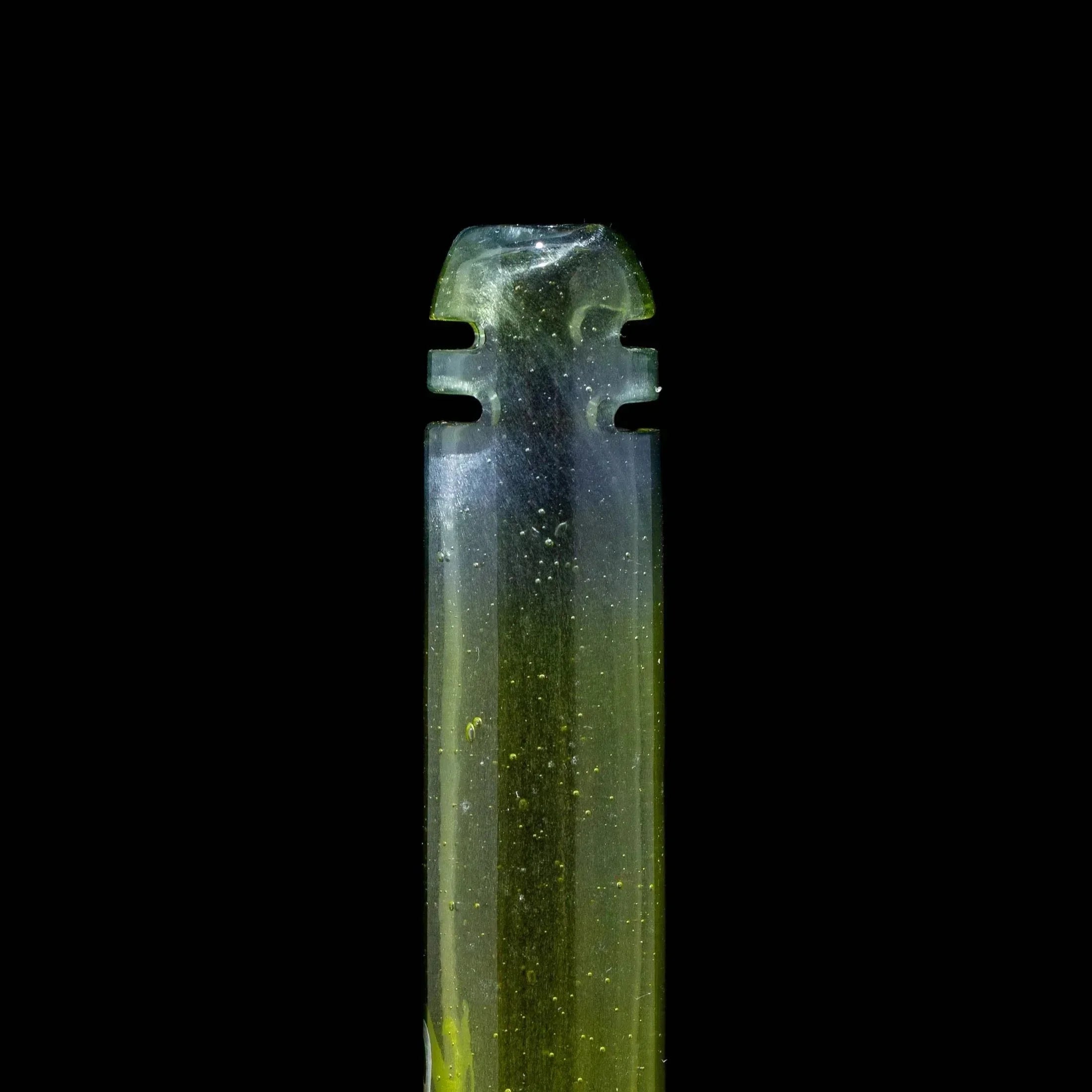 Green glass hand pipe mouthpiece close-up with airflow notches on black background