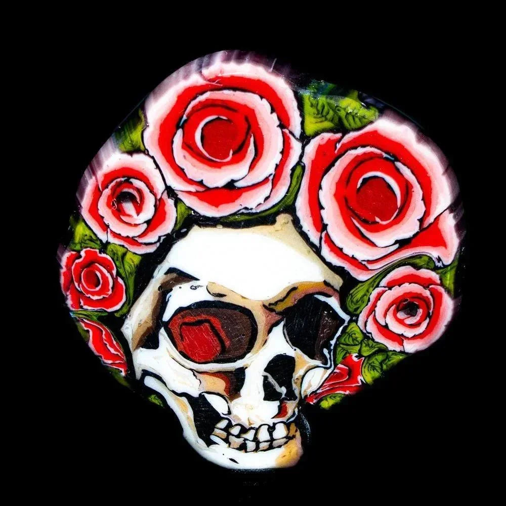 Glass art coin featuring a detailed skull with red roses on a black background