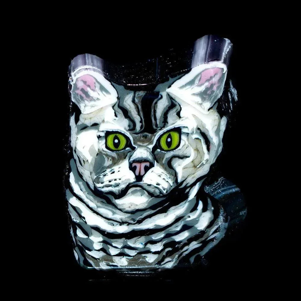 Handmade glass pendant featuring a grumpy gray tabby cat with vivid green eyes on black background.