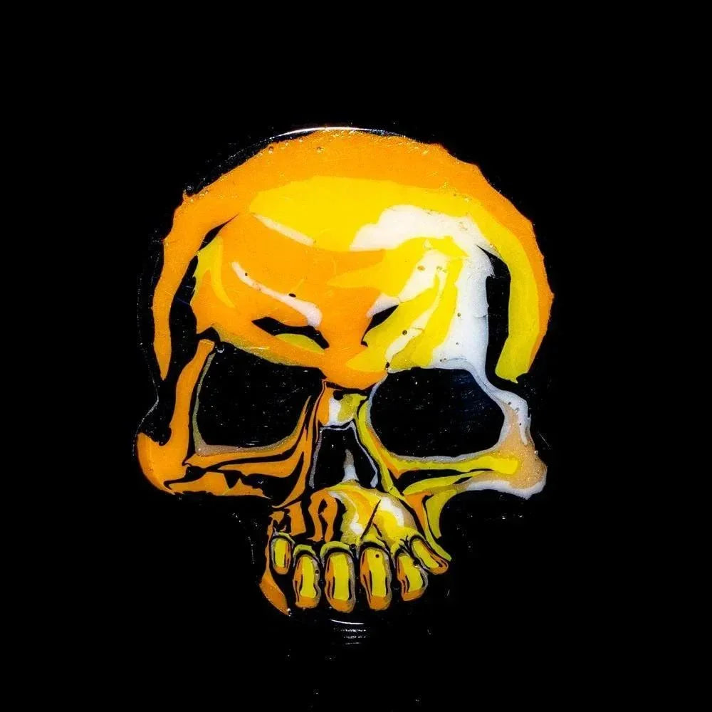 Yellow and orange glass skull art on black background, heady glass collectible