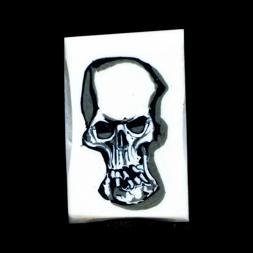 Handmade glass coin featuring a detailed skull design on a white background