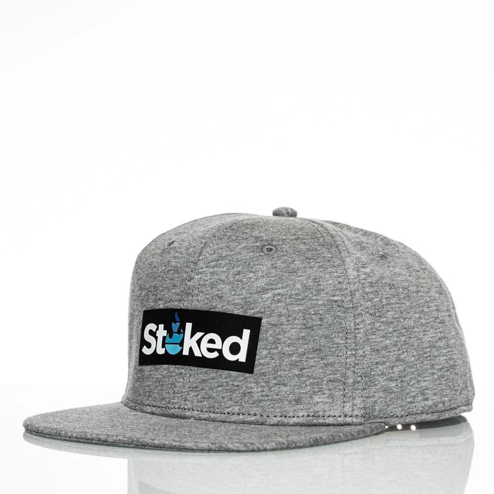 Gray Stoked snapback hat with black logo patch, featuring flame design on white background
