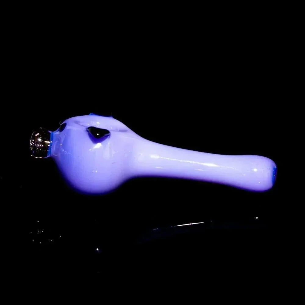 Milky purple glass spoon pipe with pig design on black background