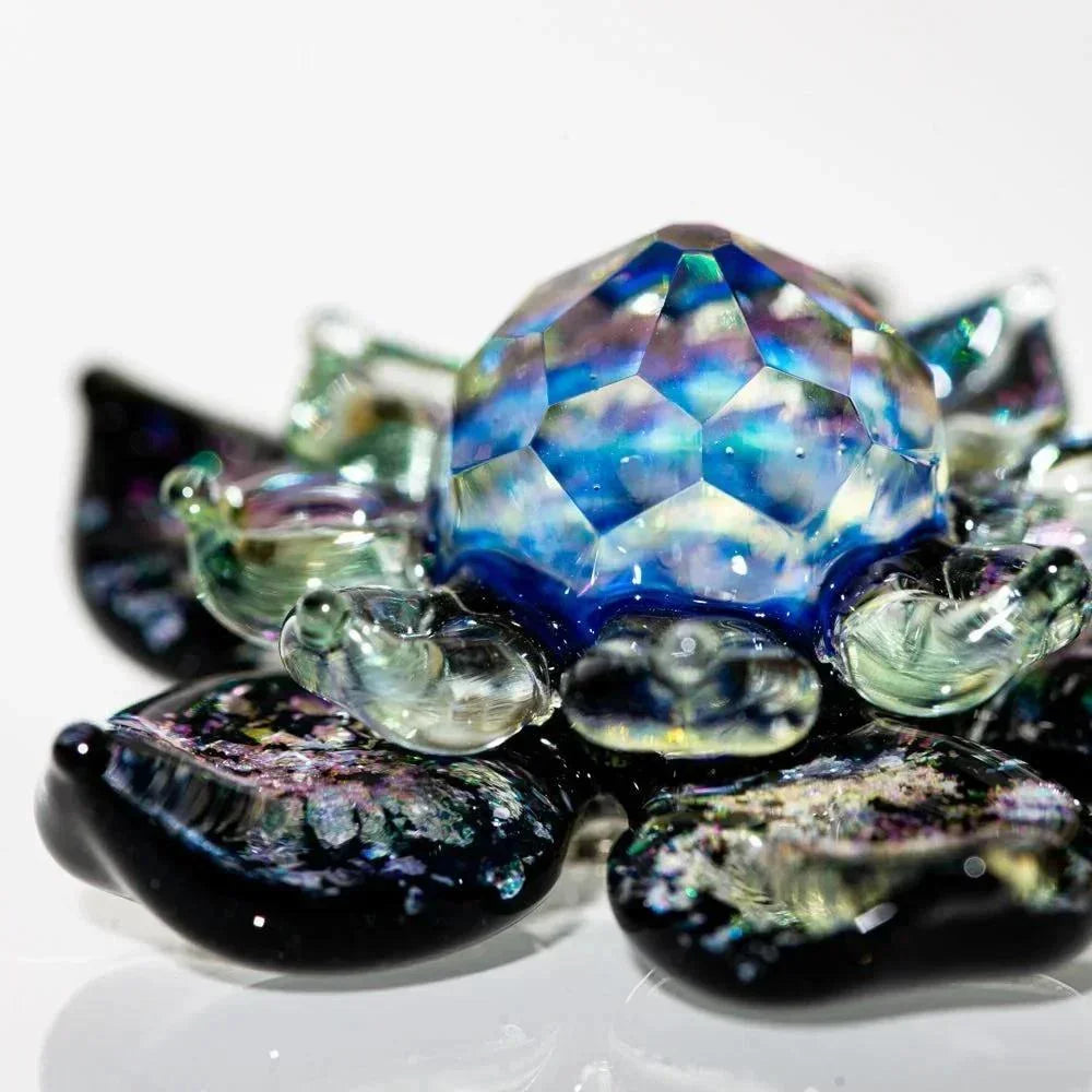 Colorful faceted glass flower pendant with iridescent petals on a white background