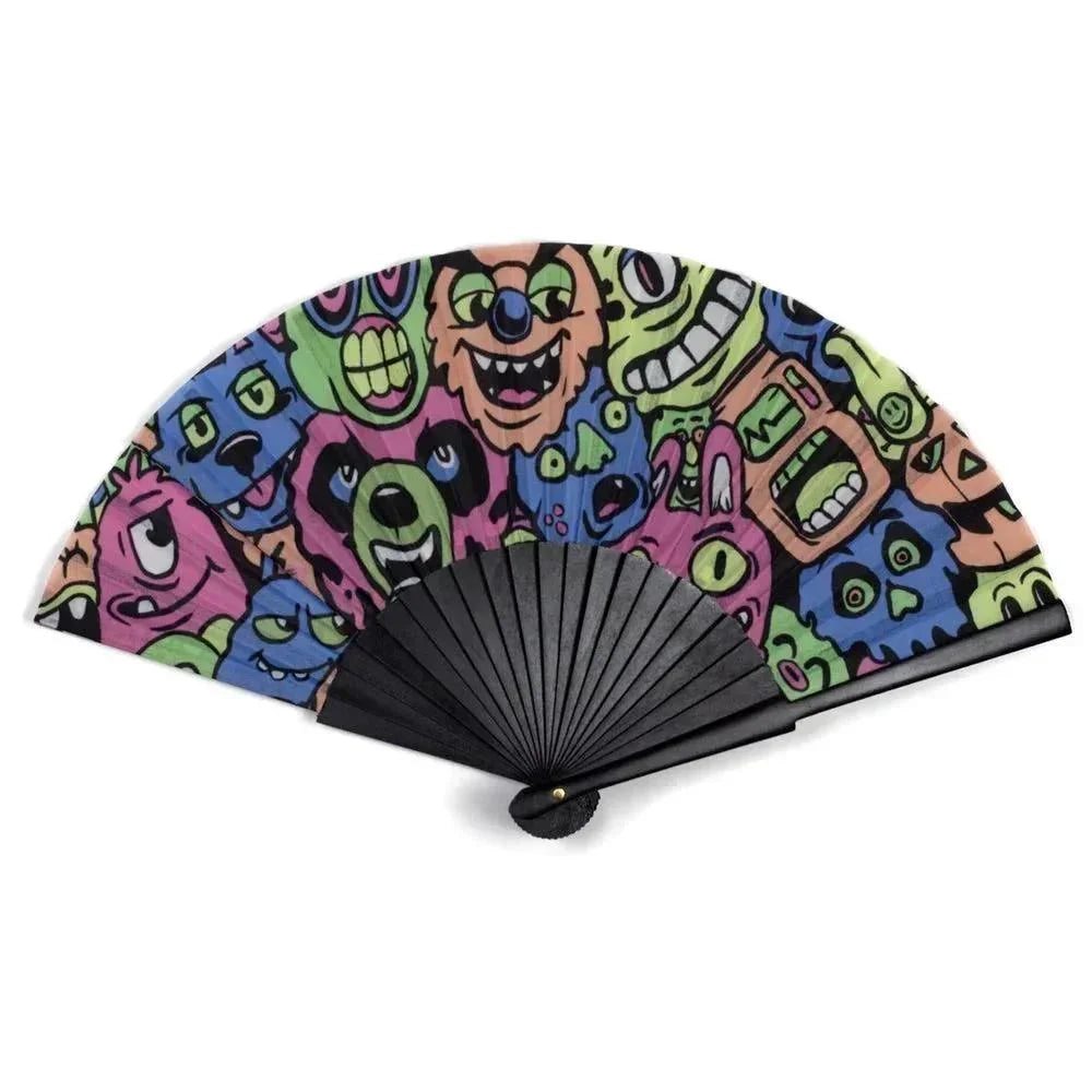 Hand fan with black ribs and colorful cartoon monster faces on the fabric