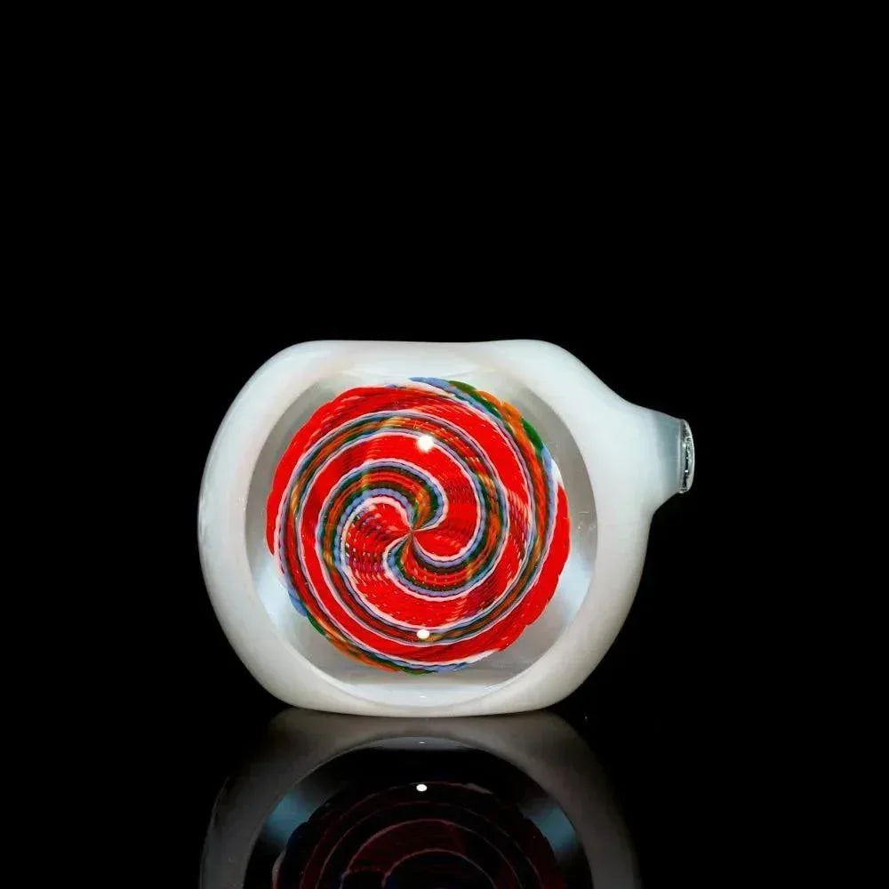 White glass hand pipe with vibrant red, blue, and orange spiral design on black background