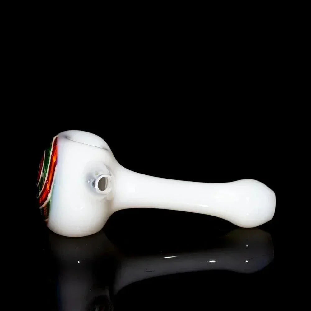 White glass hand pipe with red, orange, and green swirl design on bowl, black background