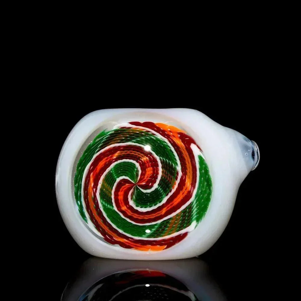 Colorful red, orange, and green spiral glass pipe with white accents on black background