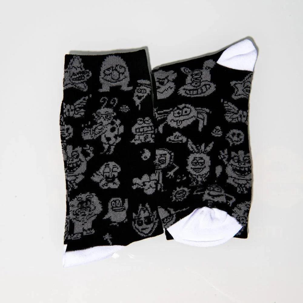 Black crew socks with grey cartoon face patterns and white toe accents on a white background.