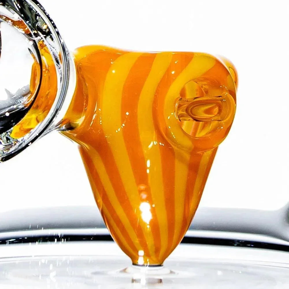 Close-up of orange and yellow striped glass pipe bowl with clear glass attachment