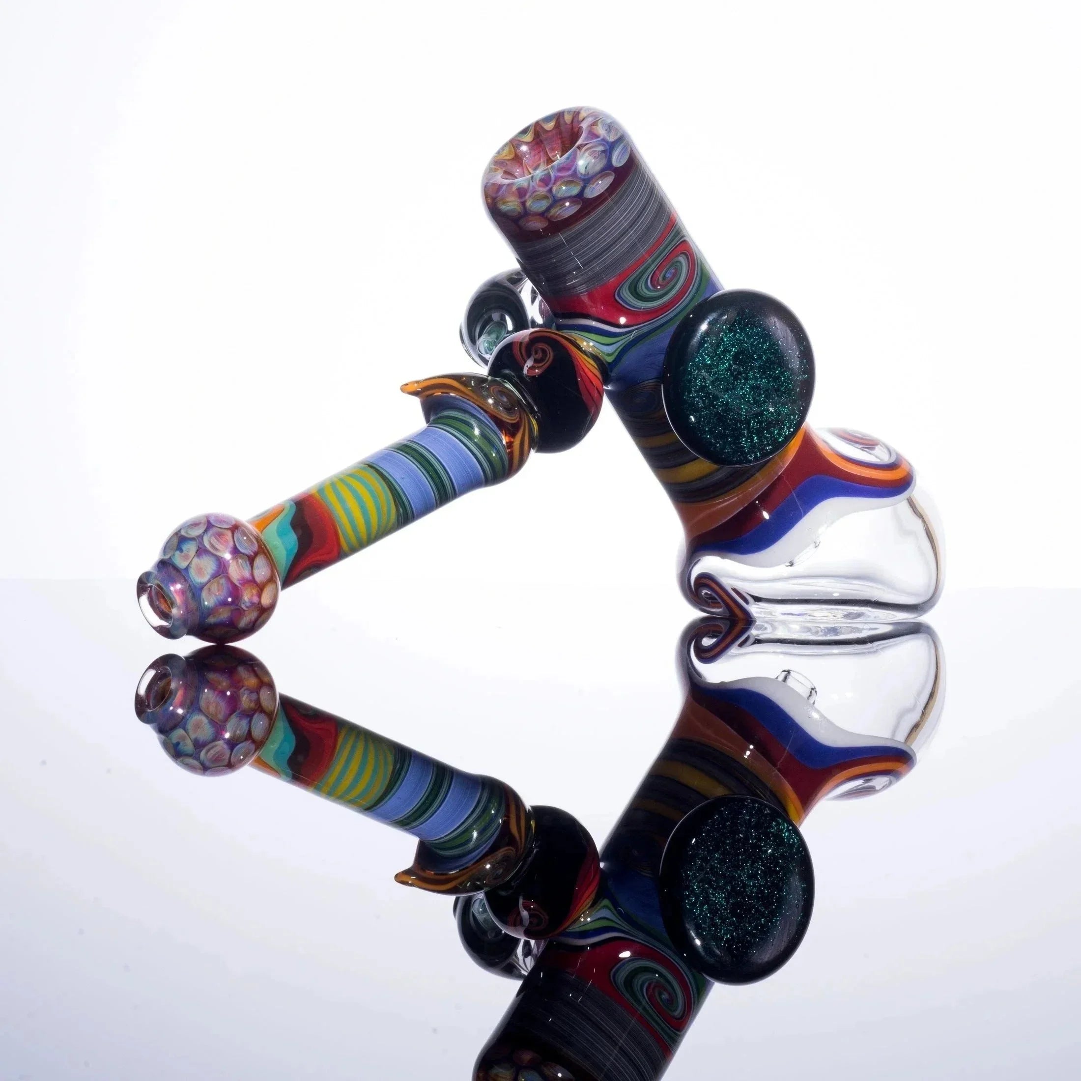 Colorful glass bubbler pipe with swirled patterns and textured details on a reflective surface.