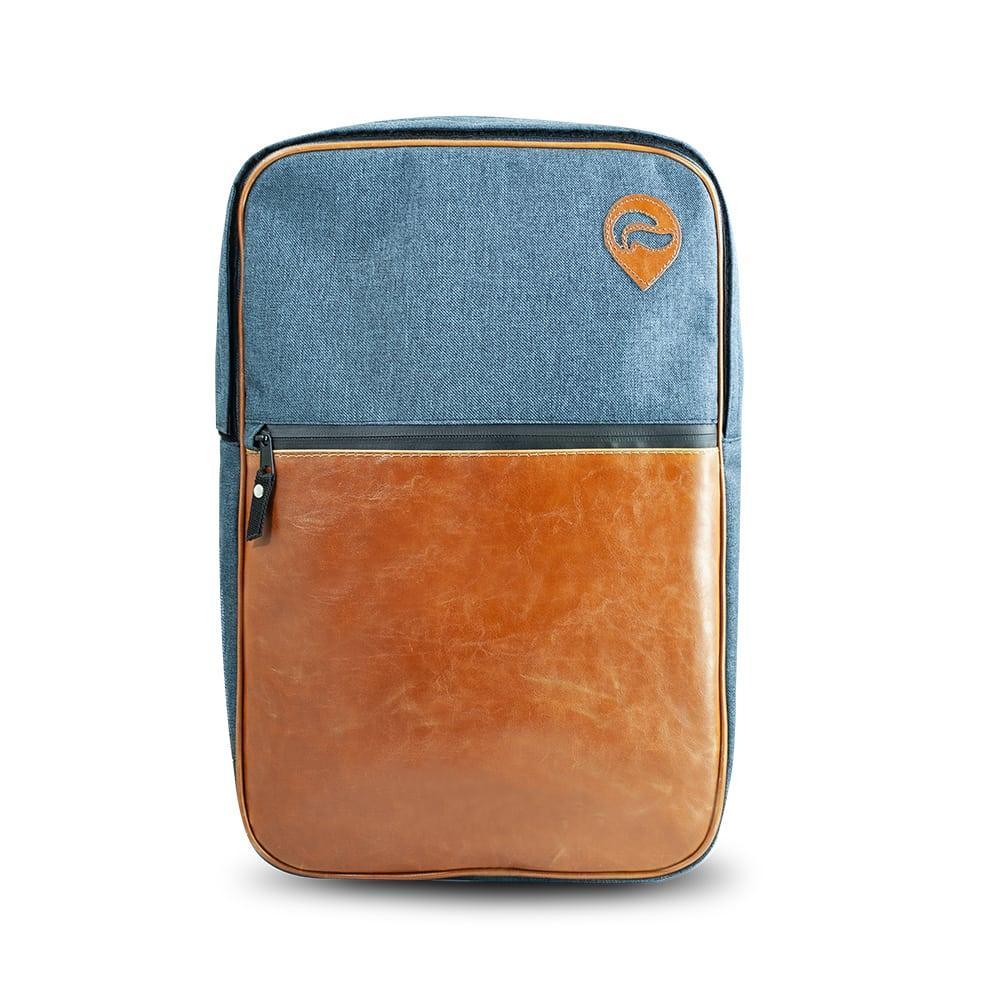 Urban backpack with denim blue fabric, tan leather front pocket, and zip closure