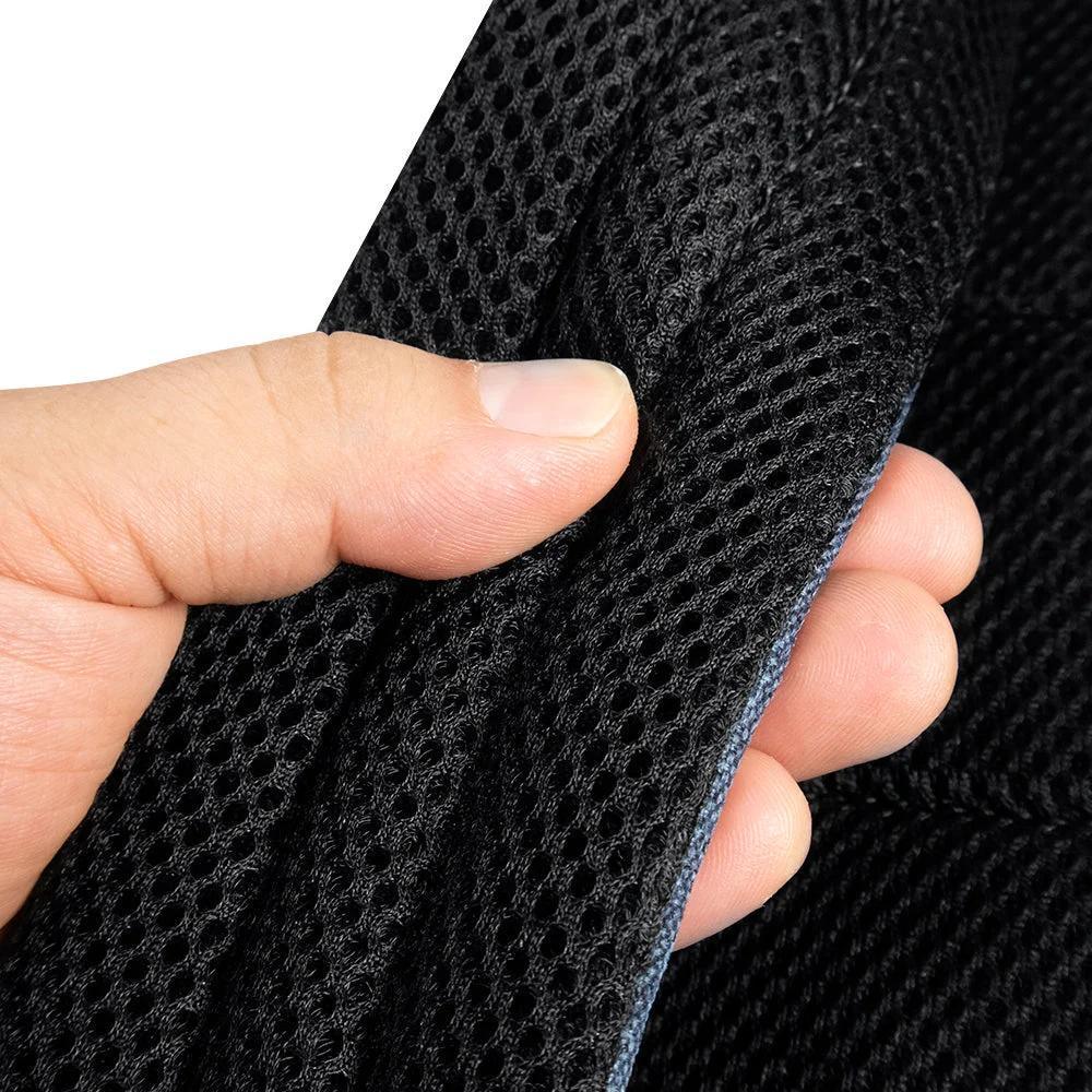 Hand holding black padded mesh backpack strap for comfort and durability