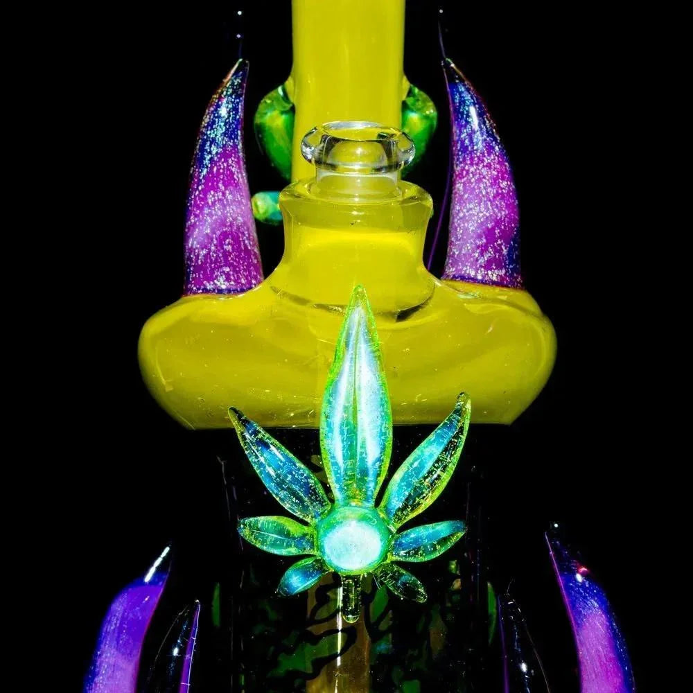 Colorful glass water pipe with glowing leaf accent and iridescent horn details on black background
